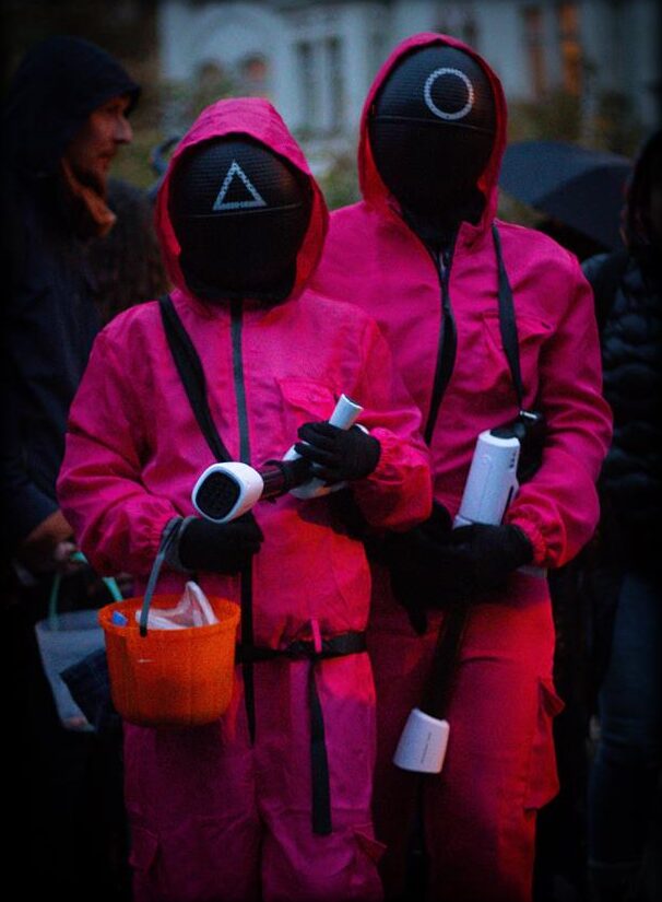 Two trick-or-treaters in pink masked costumes