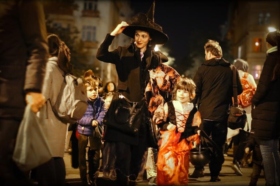 An evening crowd of trick-or-treaters on the pavement